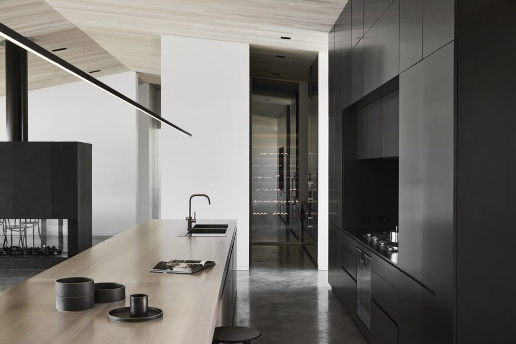 strakke zwarte moderne keuken met greeploze keukenkastjes