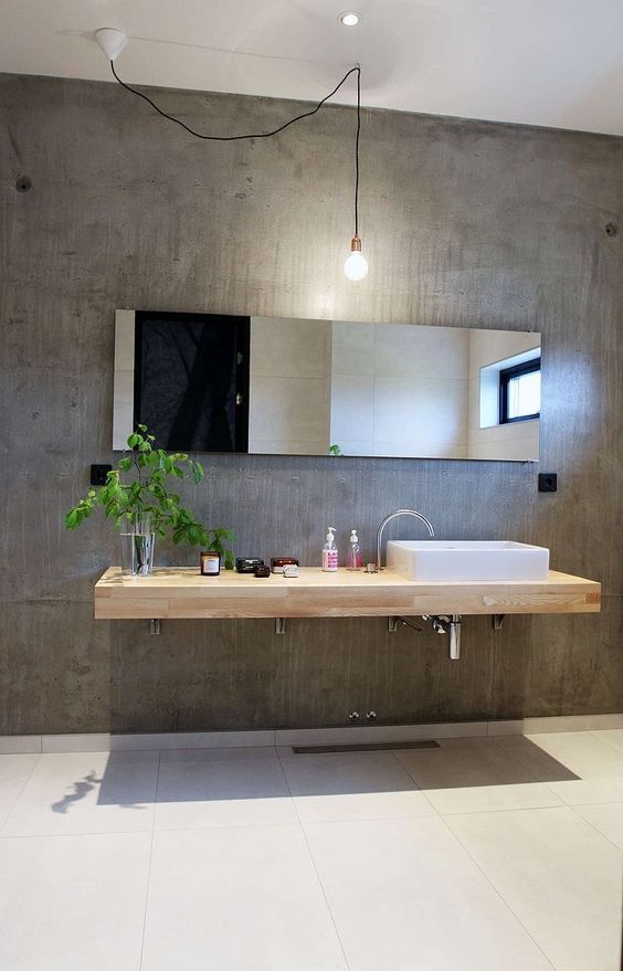 minimalistisch beton cire badkamer idee met houten wastafel en lange spiegel