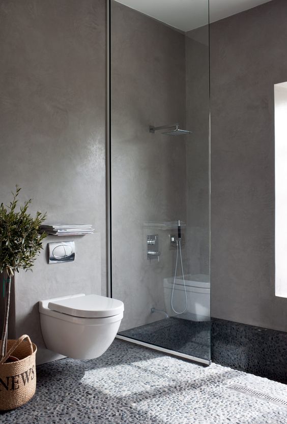beton look badkamer wand met glazen inloopdouche en kiezel badkamer tegels 