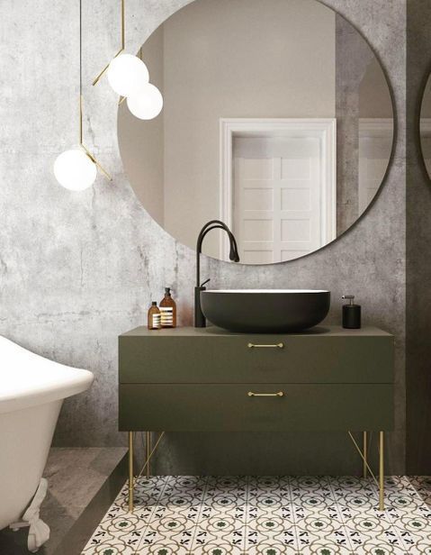 beton cire badkamer met ronde spiegel en olijf groen badkamermeubel