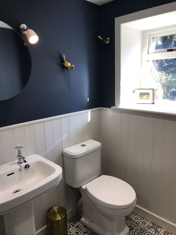 modern blauw toilet met witte wanden en gouden decoratie